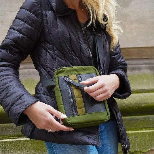Close-up of eco-friendly vegan crossbody reporter bag, upcycled rubber & military canvas design.