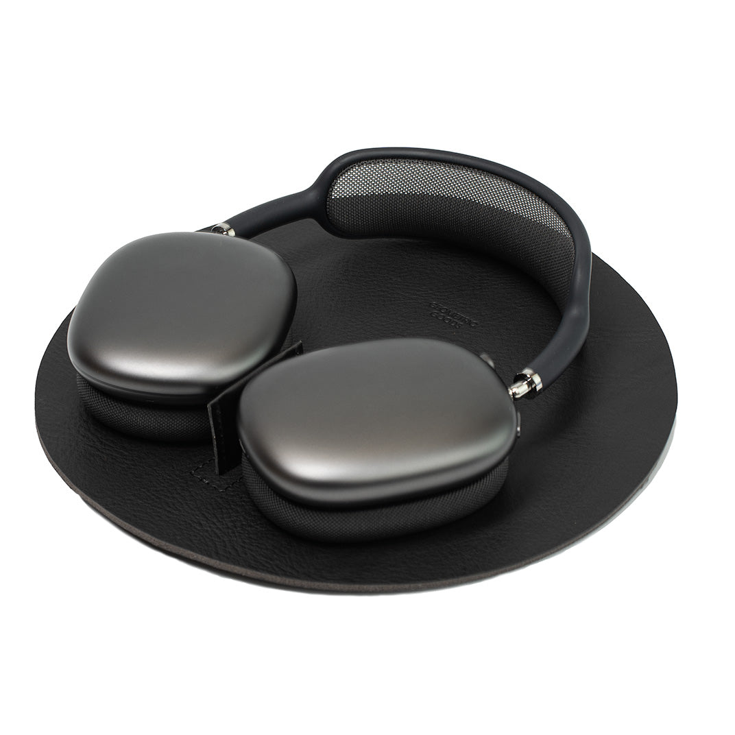 AirPods Max Rest Station in black full-grain leather – side angle view on desk.