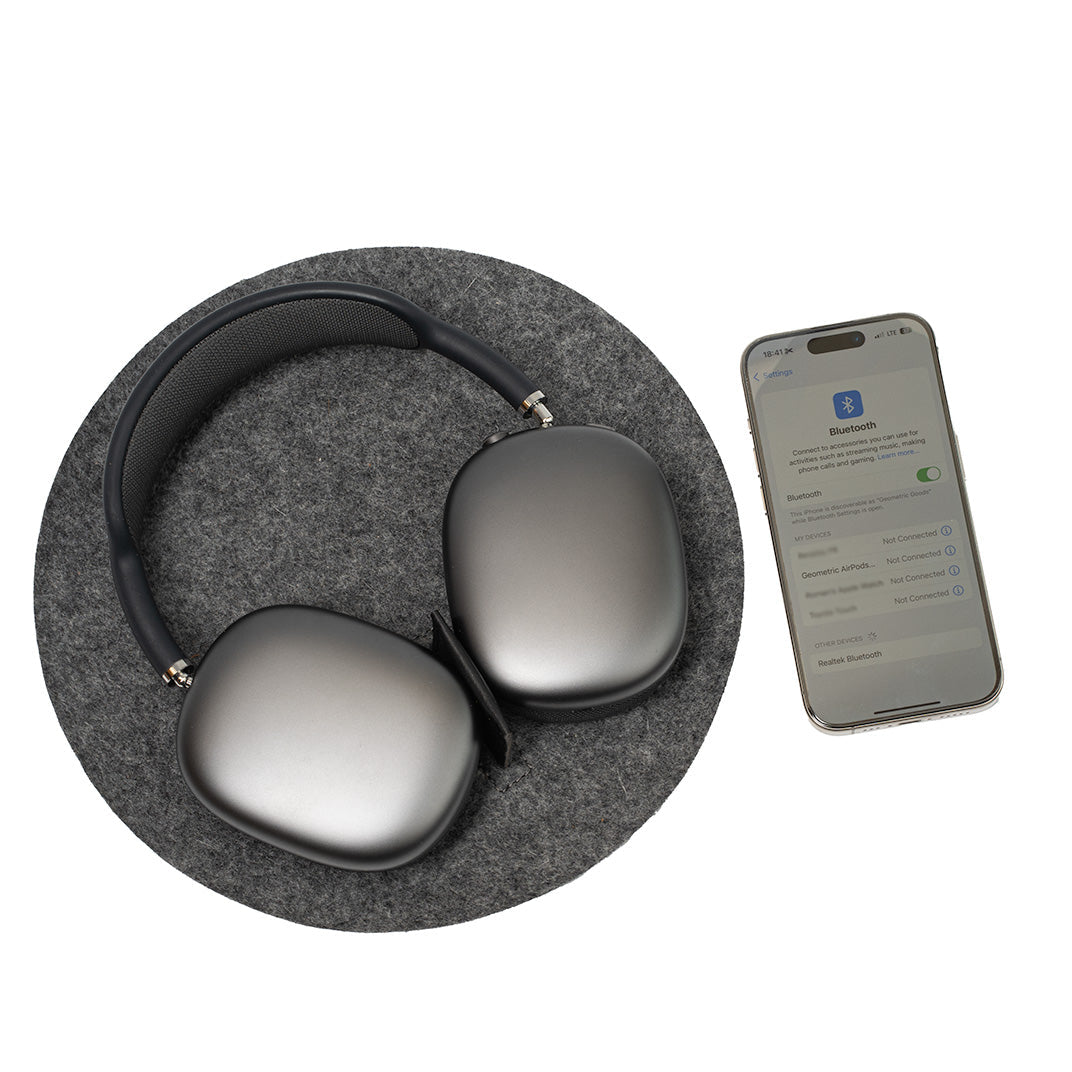AirPods Max Rest Station in gray Merino wool felt with iPhone showing Bluetooth connection.