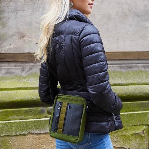 Eco-friendly crossbody reporter bag made from upcycled rubber and canvas, back view on model.