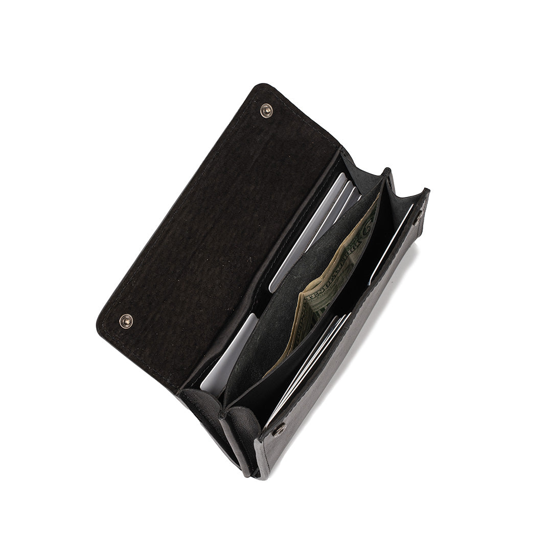Black leather AirTag wallet open showing compartments with cash and cards.