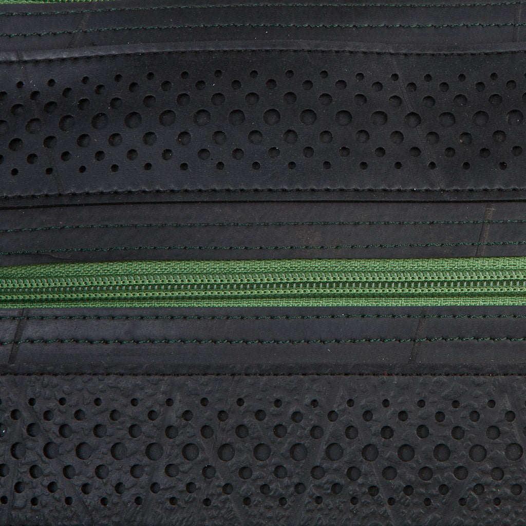 Close-up of Maggie Special recycled rubber handbag with perforated design and green zipper.